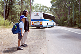 Woman and school kid waiting to cross the road
